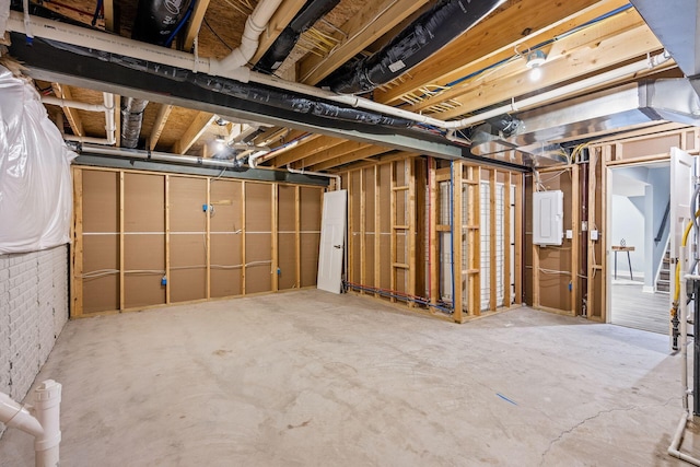 basement with electric panel and brick wall