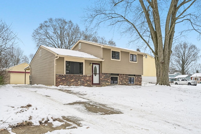 tri-level home featuring a garage and an outbuilding