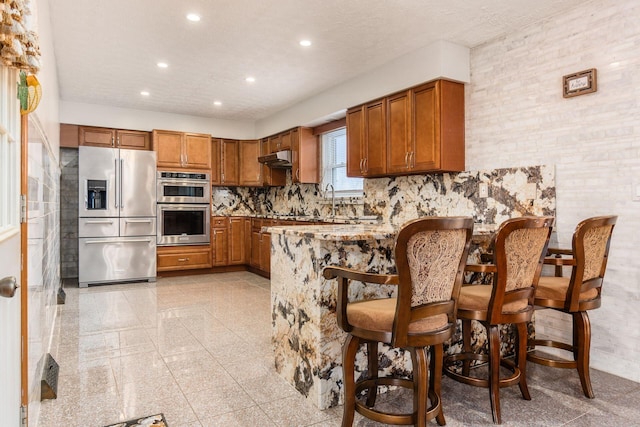 kitchen featuring stainless steel appliances, a kitchen breakfast bar, tasteful backsplash, and kitchen peninsula