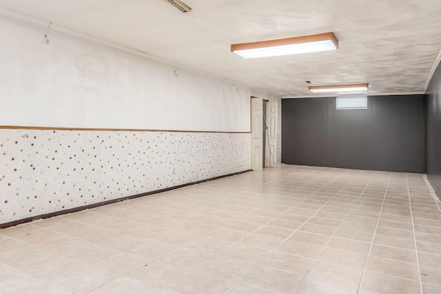 spare room featuring brick wall and light tile patterned floors