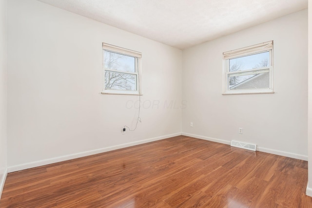 spare room featuring hardwood / wood-style flooring and a wealth of natural light