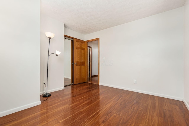 spare room featuring a textured ceiling and hardwood / wood-style floors