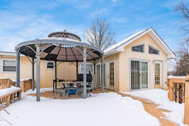 snow covered rear of property featuring a deck and a gazebo