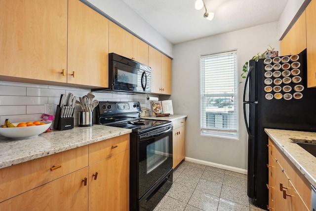 kitchen featuring black appliances, decorative backsplash, light brown cabinets, and light stone counters