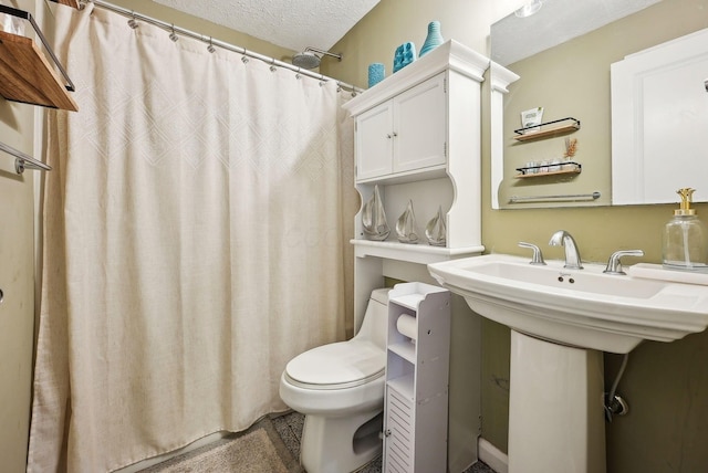 bathroom featuring a shower with shower curtain, toilet, and a textured ceiling