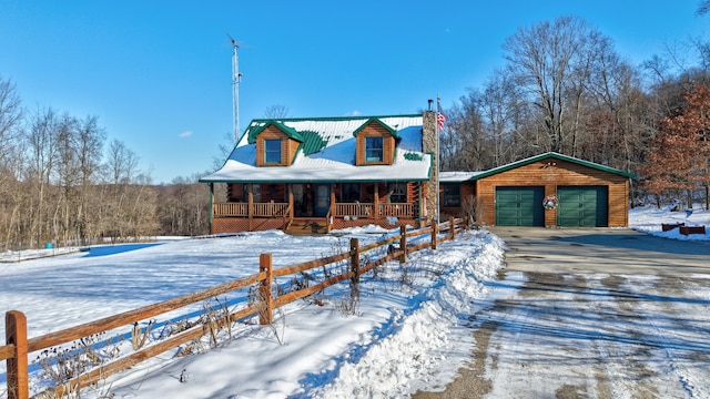 log home with covered porch, an outbuilding, and a garage