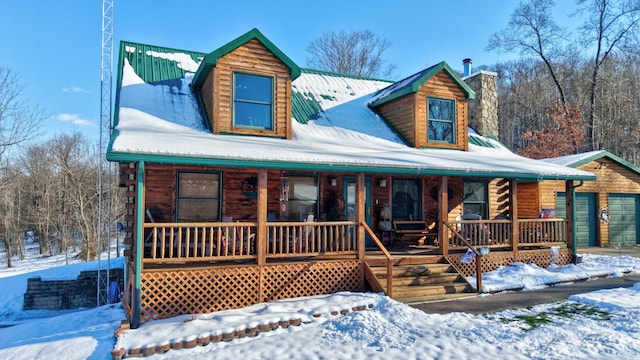 cabin featuring covered porch and a garage