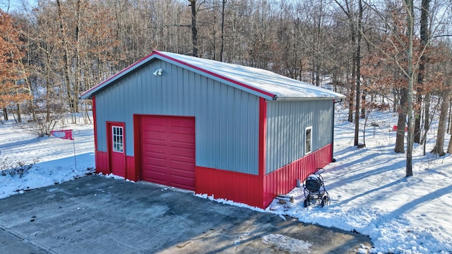 snow covered structure featuring a garage