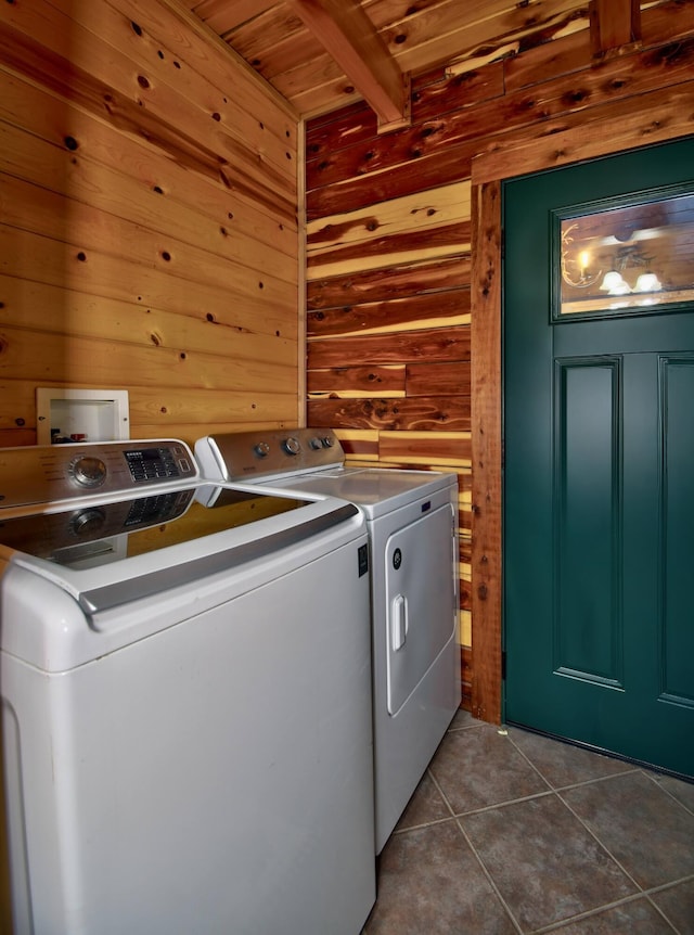 laundry room with dark tile patterned flooring, wood walls, separate washer and dryer, and wooden ceiling