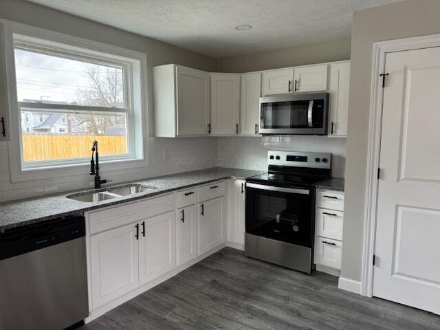 kitchen featuring sink, white cabinets, dark hardwood / wood-style floors, and appliances with stainless steel finishes