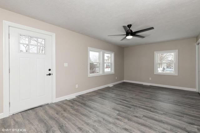 foyer featuring a textured ceiling, ceiling fan, and dark wood-type flooring