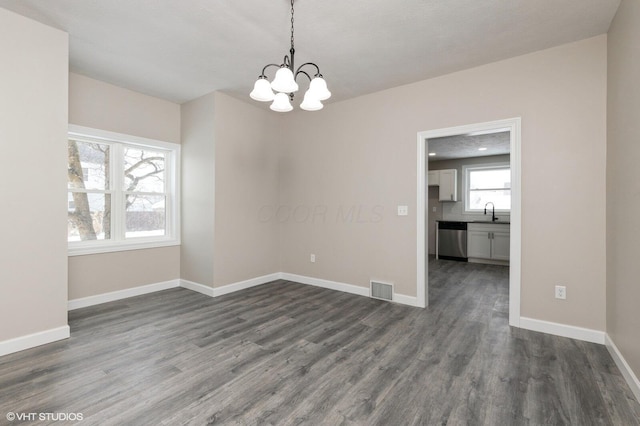 unfurnished room with dark hardwood / wood-style flooring, sink, and an inviting chandelier