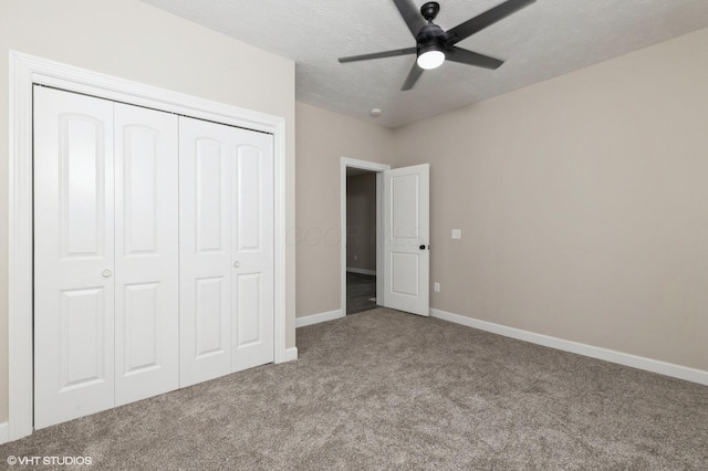 unfurnished bedroom featuring ceiling fan, light colored carpet, a textured ceiling, and a closet