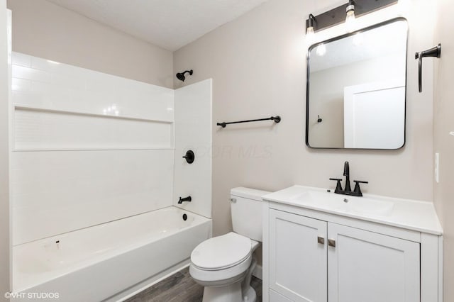 full bathroom with a textured ceiling, toilet, shower / washtub combination, vanity, and hardwood / wood-style flooring