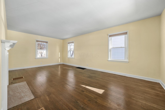 unfurnished living room with dark wood-type flooring and a high end fireplace