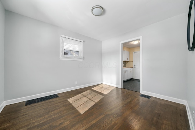 empty room with dark hardwood / wood-style flooring