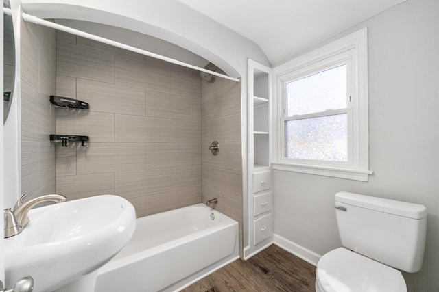 full bathroom featuring sink, wood-type flooring, tiled shower / bath combo, and toilet