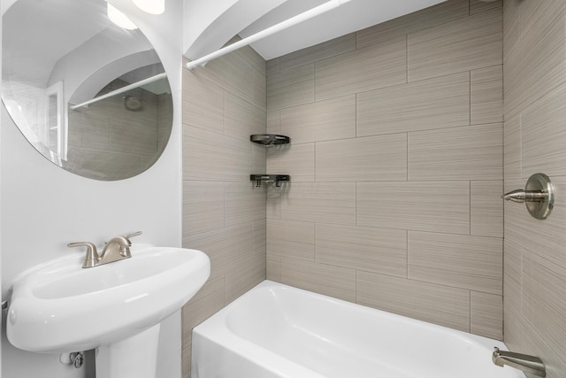 bathroom featuring tiled shower / bath combo and sink