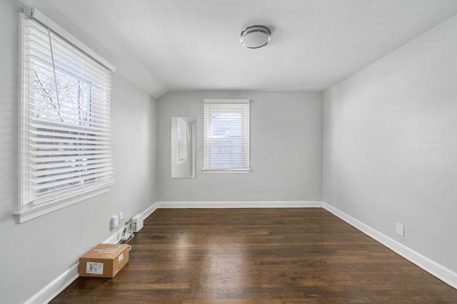 unfurnished room featuring dark hardwood / wood-style flooring and lofted ceiling