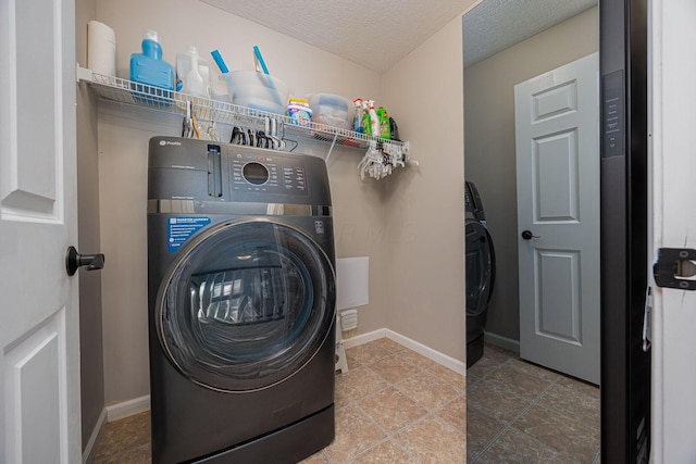 laundry room with washer / clothes dryer and a textured ceiling