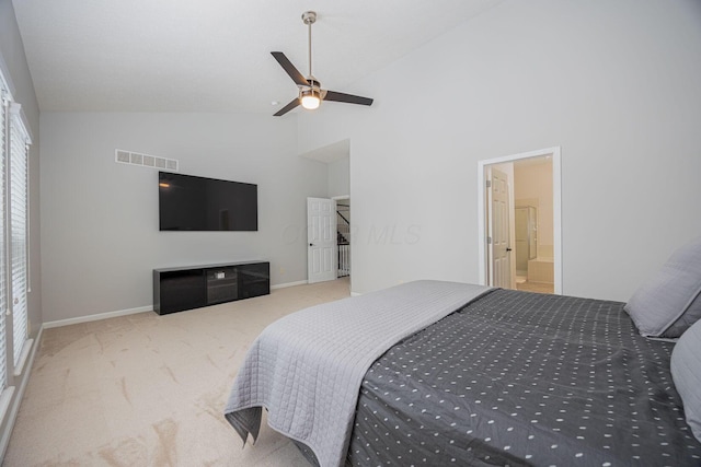 carpeted bedroom with ceiling fan, ensuite bathroom, and high vaulted ceiling