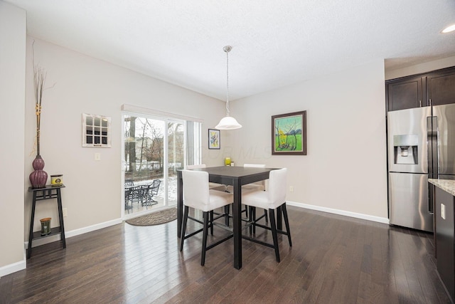 dining space with dark wood-type flooring and a textured ceiling