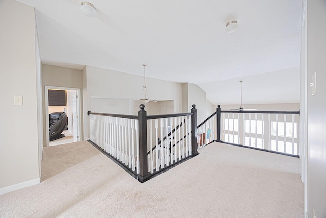 hall featuring vaulted ceiling and light colored carpet