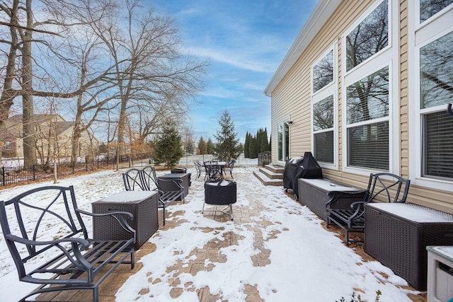 snow covered patio with a grill