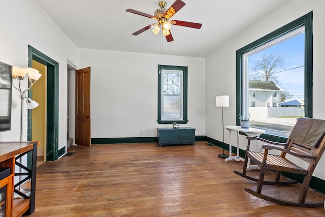 living area featuring hardwood / wood-style flooring and ceiling fan