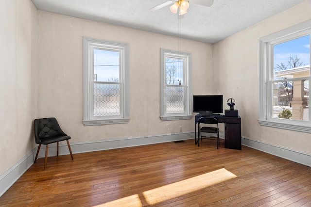 office space featuring a textured ceiling, hardwood / wood-style flooring, and ceiling fan