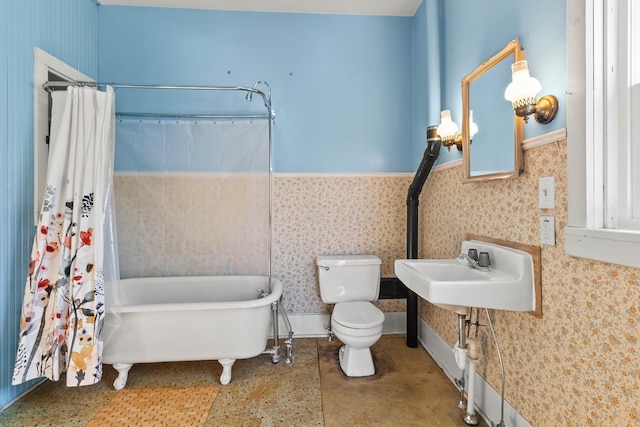 bathroom with a tub to relax in, toilet, and sink