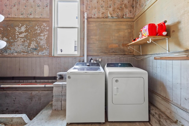 washroom featuring wood walls and washer and clothes dryer