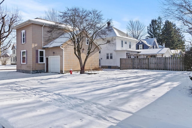 snow covered house with a garage