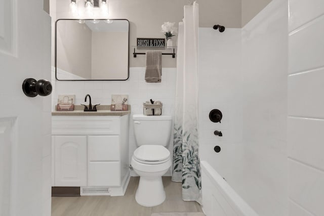 full bathroom with hardwood / wood-style floors, toilet, vanity, and shower / bath combo