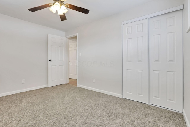 unfurnished bedroom featuring ceiling fan, a closet, and light carpet