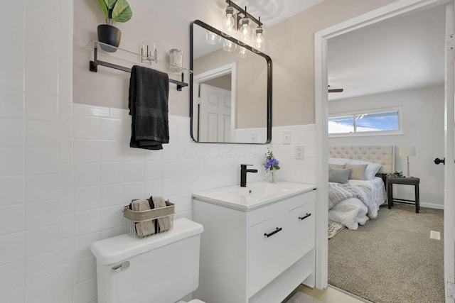 bathroom featuring tile walls, vanity, and toilet