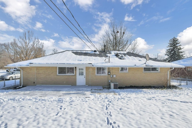 snow covered property featuring central AC