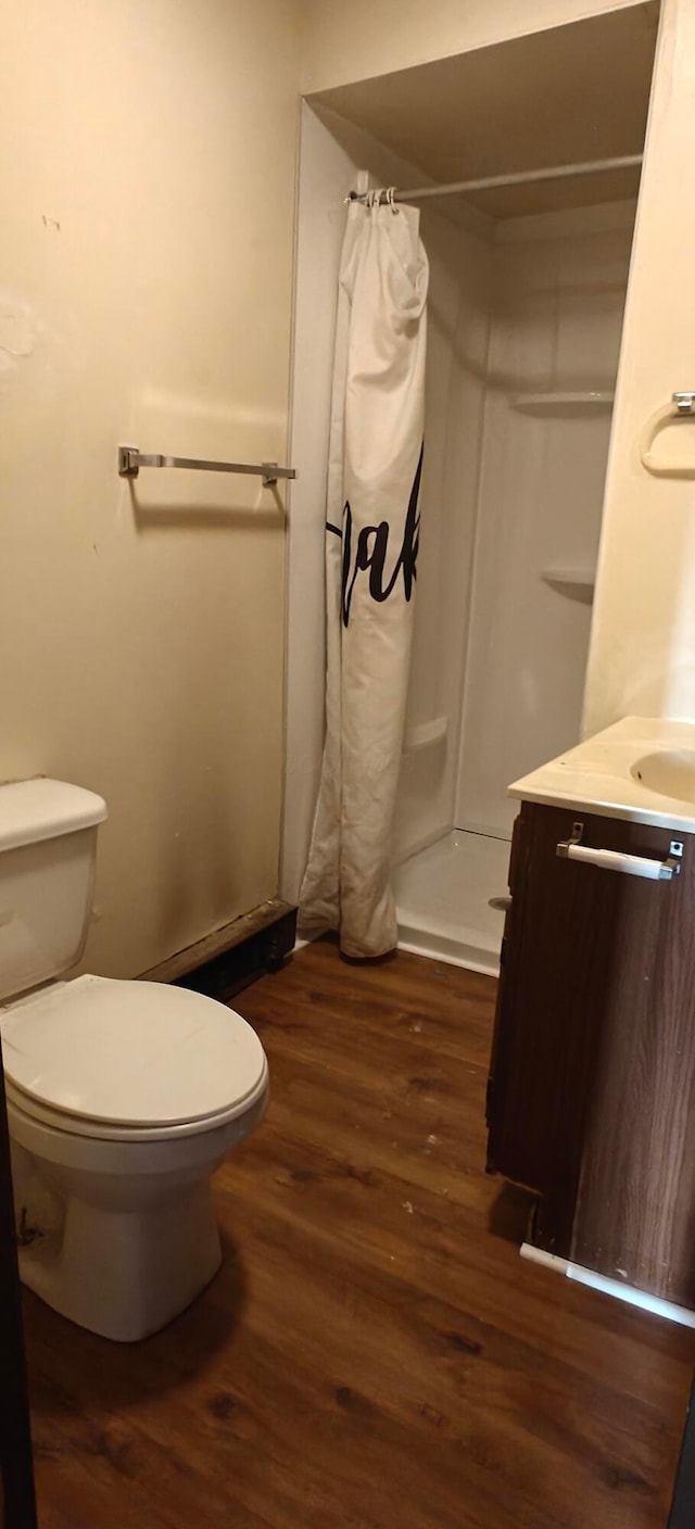 bathroom with vanity, toilet, wood-type flooring, and walk in shower