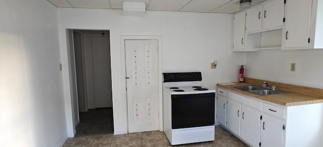 kitchen with electric stove, white cabinets, and sink