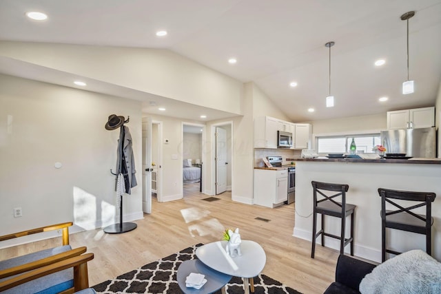 living room with lofted ceiling and light wood-type flooring