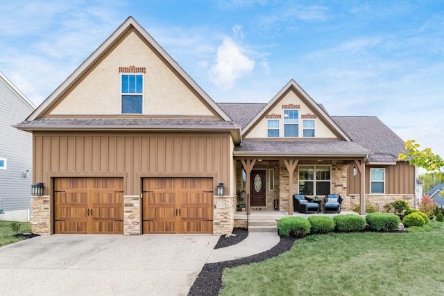 craftsman inspired home featuring a porch, a garage, and a front yard