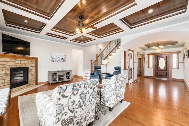 living room with coffered ceiling, hardwood / wood-style floors, crown molding, and a fireplace