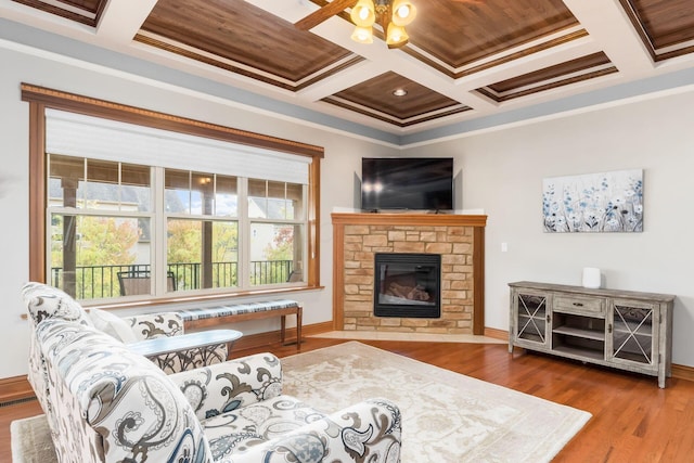 living room with coffered ceiling, wood-type flooring, ornamental molding, and a fireplace