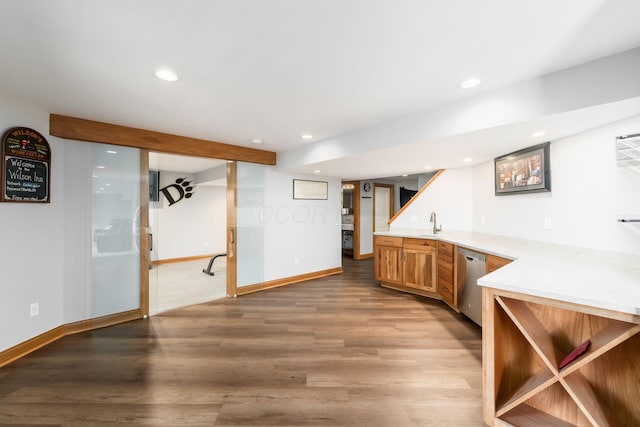 bar with stainless steel dishwasher, sink, and light wood-type flooring