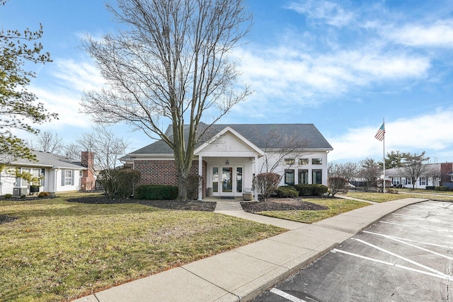 view of front of property featuring a front yard and french doors