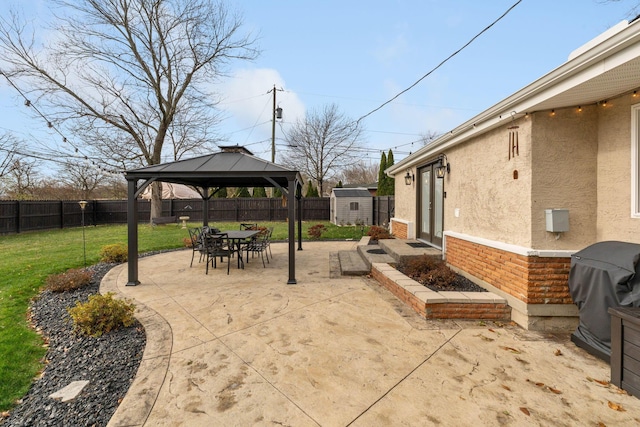 view of patio / terrace featuring a gazebo, area for grilling, and a storage shed