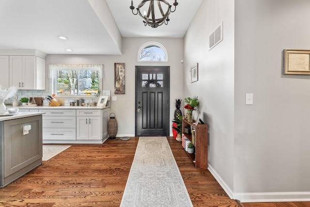 entrance foyer featuring dark wood-type flooring and a chandelier