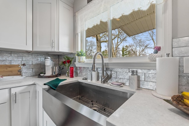 kitchen with white cabinets, sink, a wealth of natural light, and tasteful backsplash