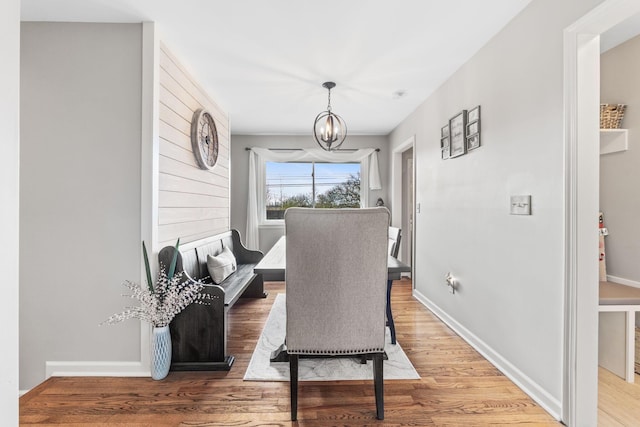 dining area featuring hardwood / wood-style floors and an inviting chandelier