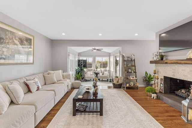 living room with a tiled fireplace, ceiling fan, dark hardwood / wood-style flooring, and lofted ceiling